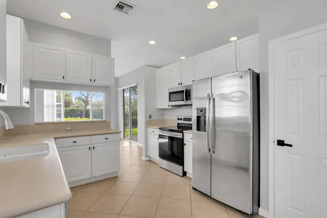 a kitchen with stainless steel appliances a refrigerator sink and microwave