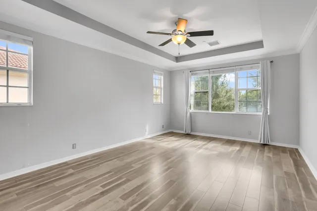 a view of an empty room with a window and wooden floor