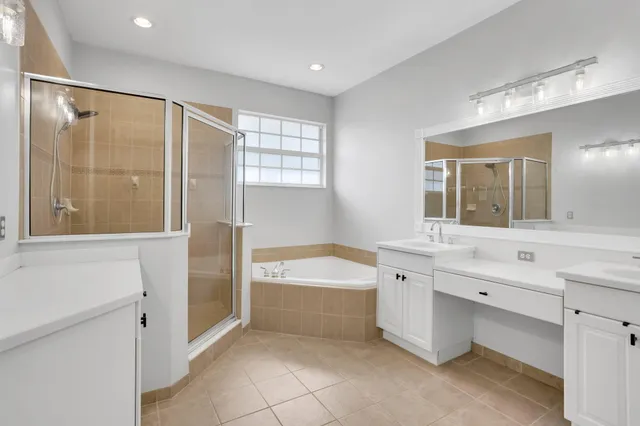 a spacious bathroom with a tub sink shower and mirror