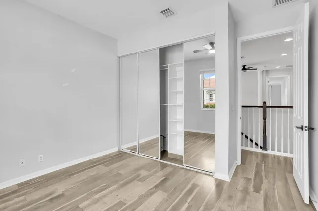 an empty room with wooden floor and a bathroom