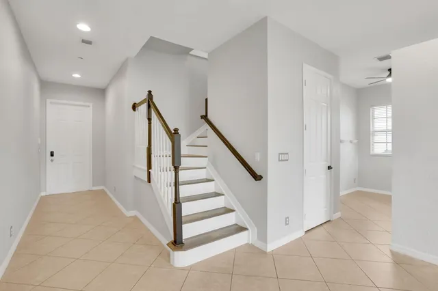a view of a hallway with entryway and stairs