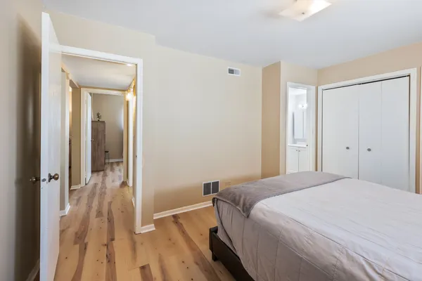 a bedroom with a bed and a wooden floor