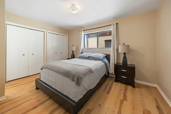 a bedroom with a bed and wooden floor