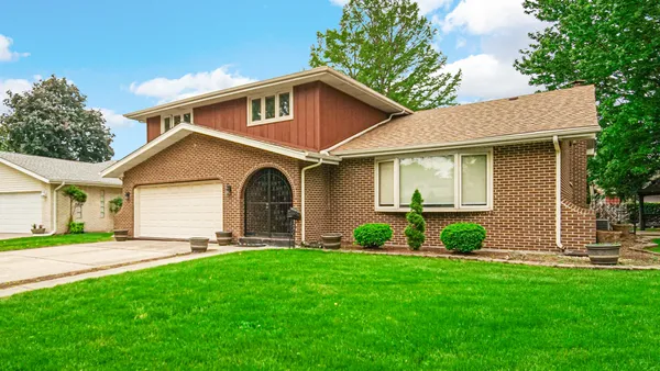 a front view of a house with a garden and yard