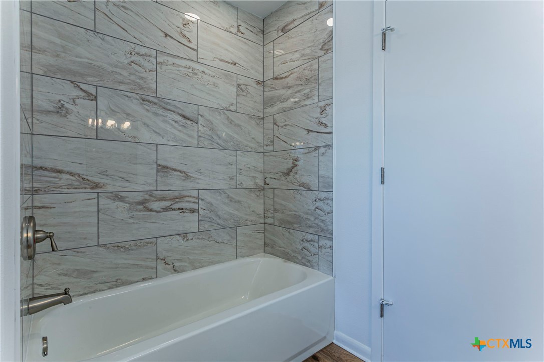 301 Thomas Street Rogers, TX 76569 - Photo 16 of 29 a bathroom with a bathtub and shower