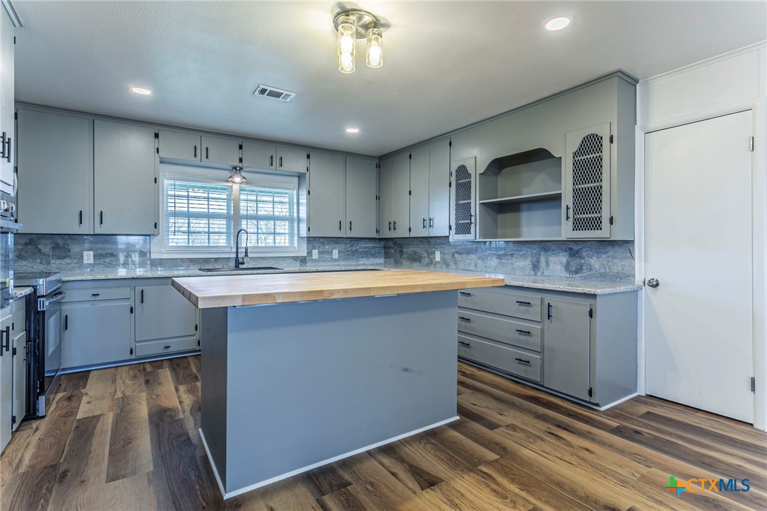 301 Thomas Street Rogers, TX 76569 - Photo 5 of 29 a kitchen with granite countertop a stove a sink and a microwave