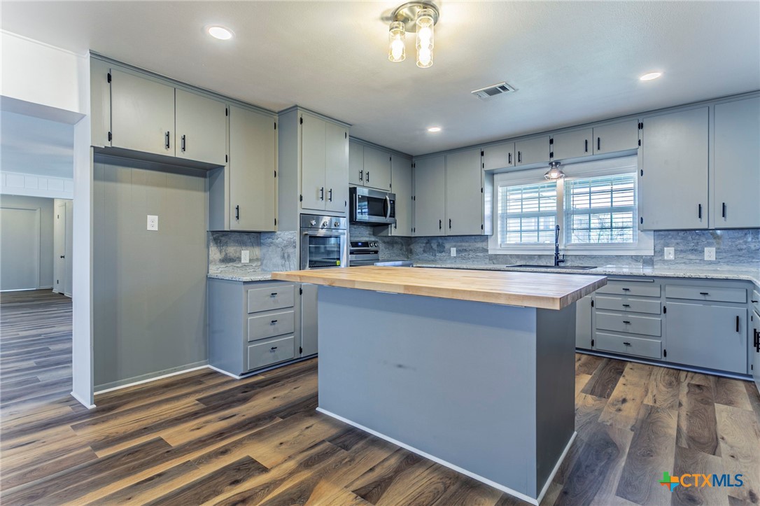 301 Thomas Street Rogers, TX 76569 - Photo 6 of 29 a kitchen with cabinets a sink and appliances