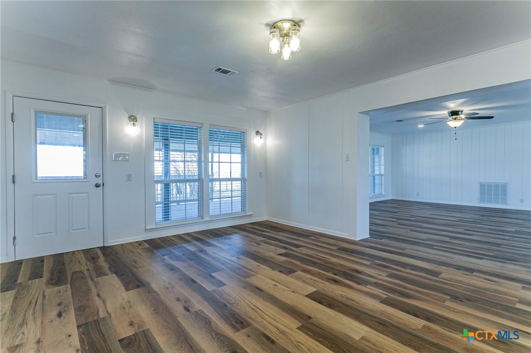 301 Thomas Street Rogers, TX 76569 - Photo 8 of 29 a view of an empty room with wooden floor and a window