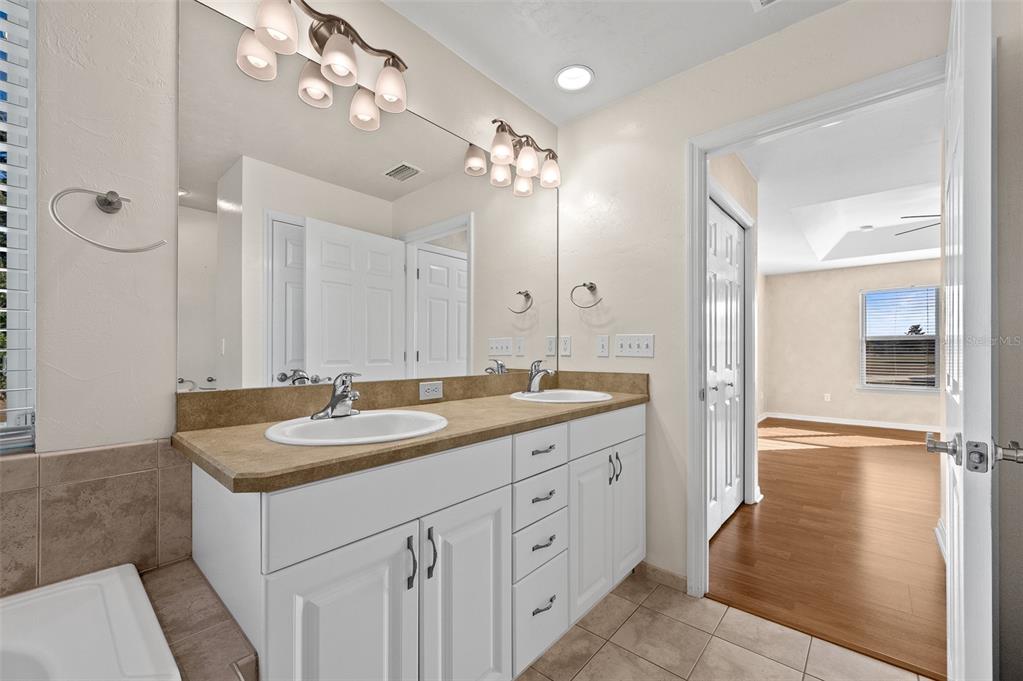 10215 Southwest 98th Avenue Gainesville, FL 32608 - Photo 26 of 43 a bathroom with a granite countertop sink a large mirror and shower