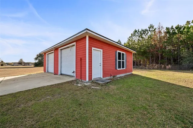 a view of a house with backyard and trees