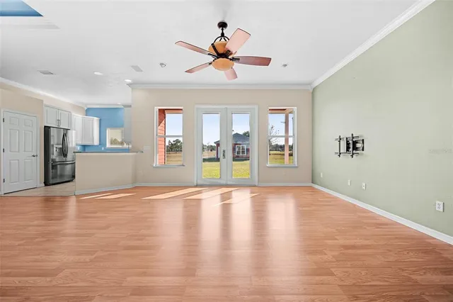 a view of an empty room with a window and wooden floor