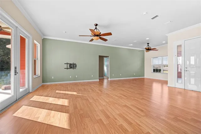 a view of an empty room with kitchen and a window