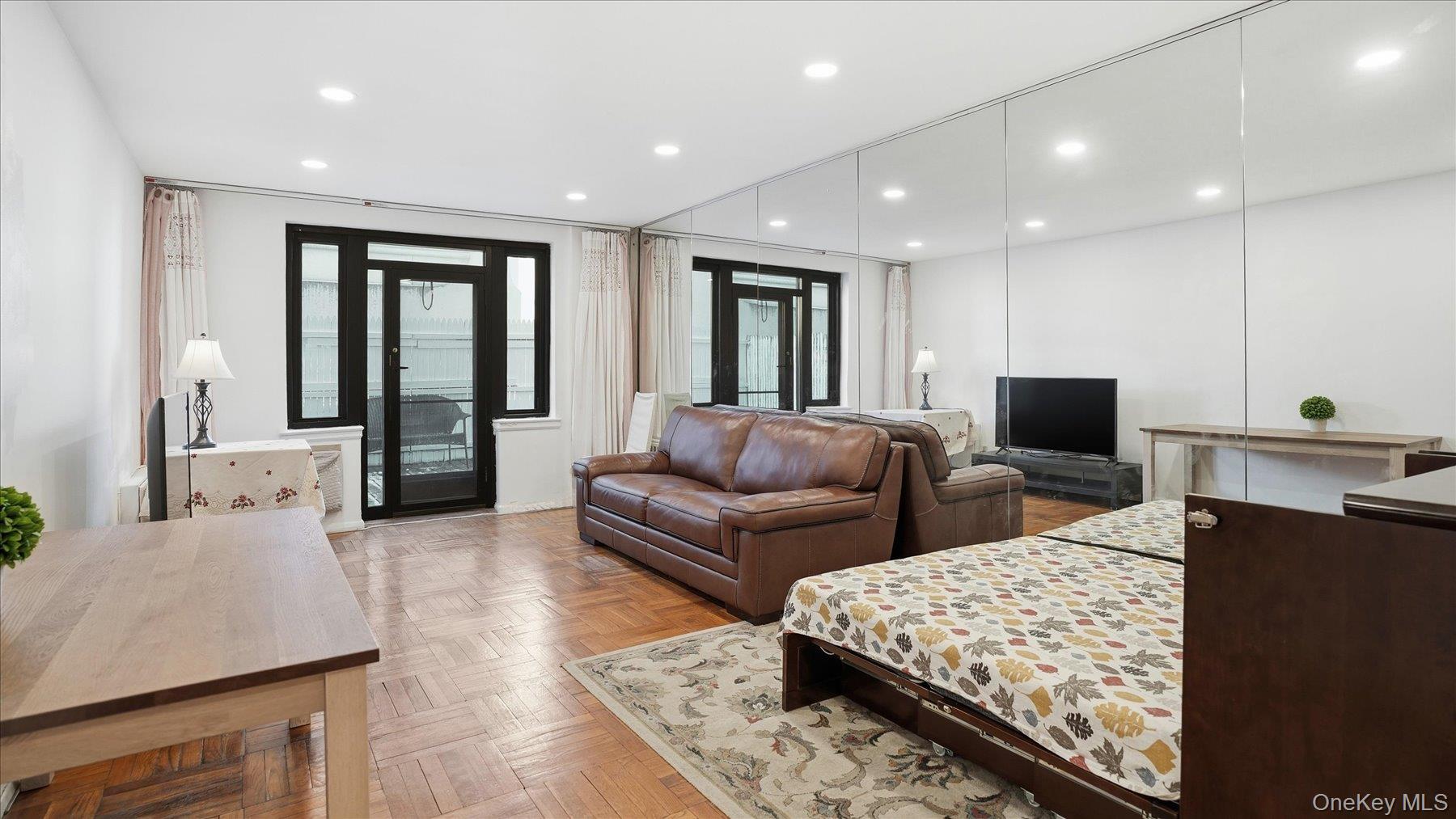 46 Grace Avenue, Unit 1L Great Neck, NY 11021 - Photo 5 of 16 a living room with furniture and a flat screen tv