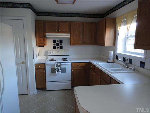 4621 Drewbridge Way Raleigh, NC 27604 - Photo 6 of 25 Enjoy New kitchen sink in this bright & sunny kitchen with pantry, tile floor, side by side refrigerator with water on the door.