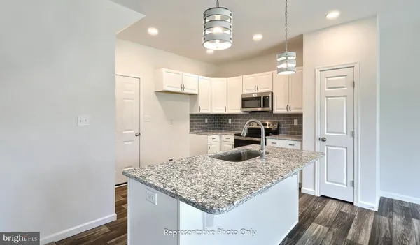 a kitchen with stainless steel appliances granite countertop a sink refrigerator and microwave