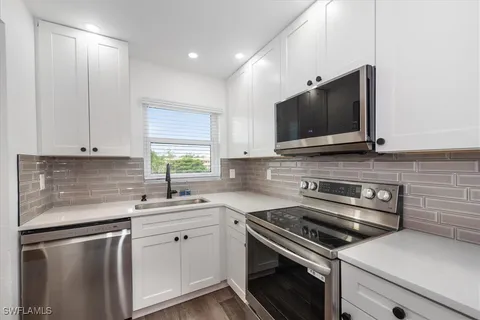 a kitchen with stainless steel appliances a sink stove and microwave