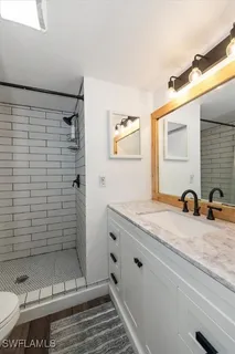 a bathroom with a granite countertop sink a toilet and shower