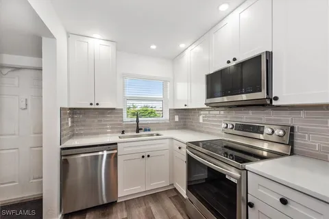 a kitchen with a sink stove and microwave