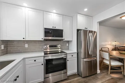 a kitchen with refrigerator a microwave a stove and cabinets
