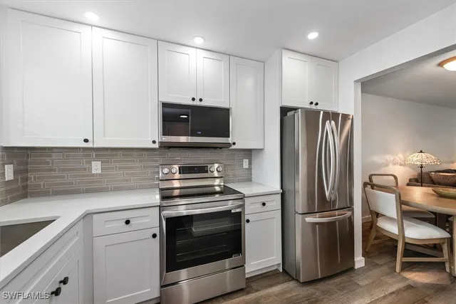 a kitchen with refrigerator a microwave a stove and cabinets