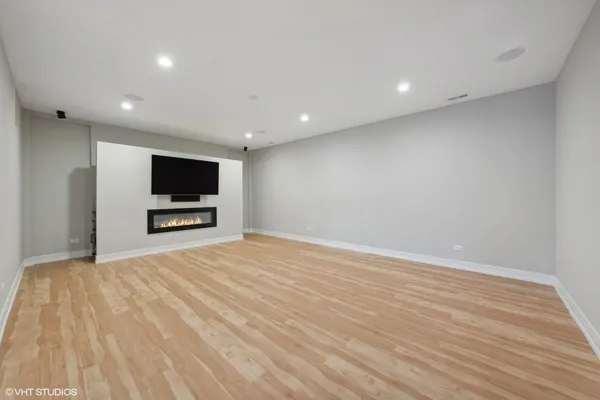 a view of room with wooden floor and flat screen tv