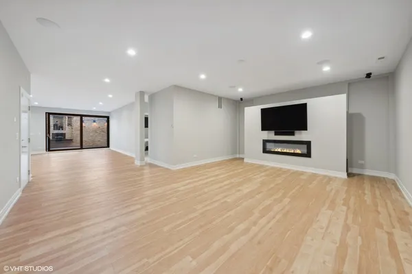 a view of empty room with wooden floor and flat screen tv