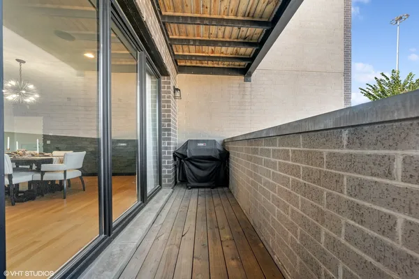 a view of a balcony with chairs and wooden floor