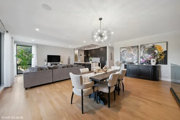 a view of a dining room with furniture a rug and wooden floor