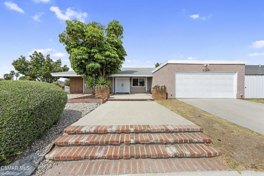 2125 Yosemite Avenue Simi Valley, CA 93063 - Photo 1 of 31 a front view of a house with a yard and a garage