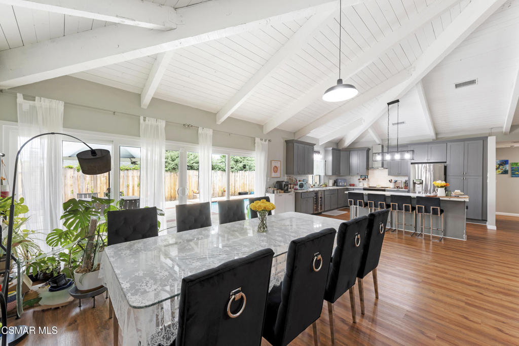 2125 Yosemite Avenue Simi Valley, CA 93063 - Photo 10 of 31 a kitchen with stainless steel appliances granite countertop a stove a refrigerator a dining table and chairs with wooden floor