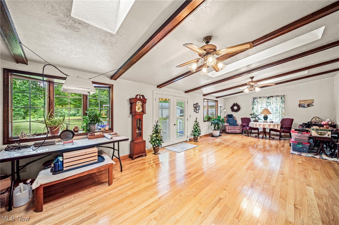 2921 Sexton Road Geneva, OH 44041 - Photo 28 of 43 Miscellaneous room with beamed ceiling, hardwood / wood-style floors, a textured ceiling, a ceiling fan, and a skylight