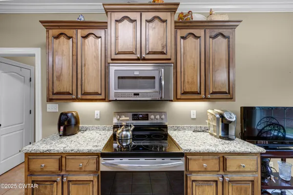 a kitchen with kitchen island granite countertop a sink appliances and cabinets