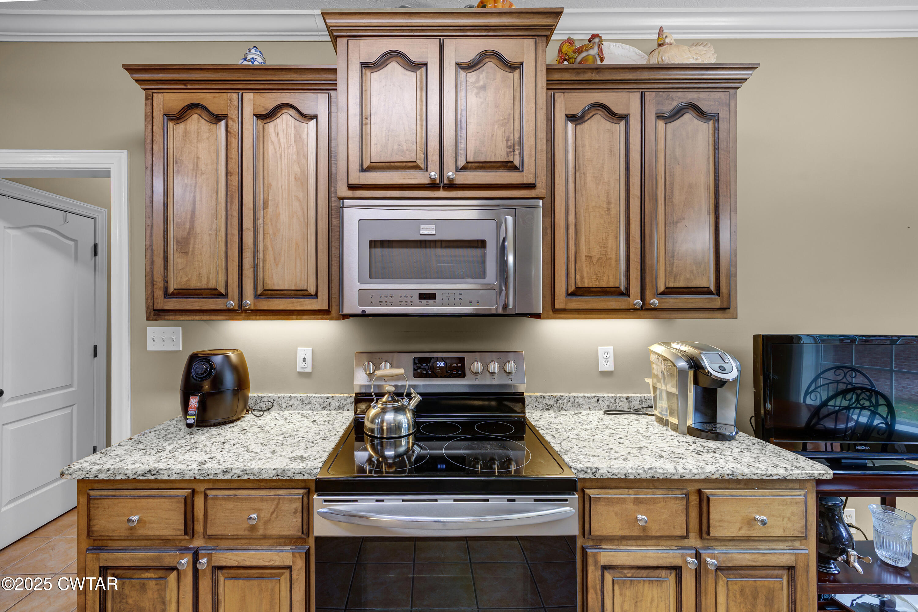 3 Emerald Ridge Cove Jackson, TN 38305 - Photo 14 of 26 a kitchen with granite countertop wood cabinets and a stove top oven