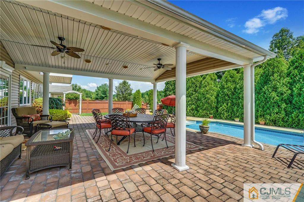 60 Higgins Road Old Bridge, NJ 08857 - Photo 22 of 25 a view of a patio with table and chairs potted plants with wooden floor and fence