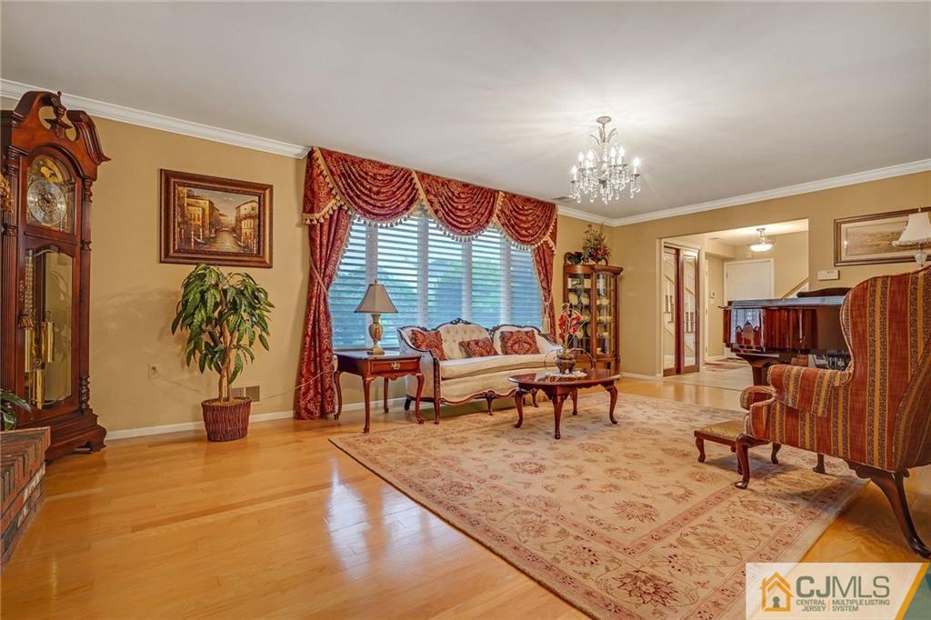 60 Higgins Road Old Bridge, NJ 08857 - Photo 8 of 25 a living room with furniture a chandelier and a dining table with wooden floor