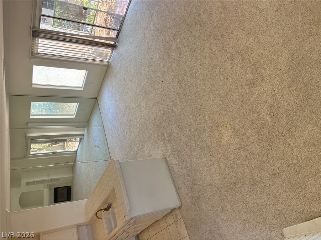 5272 Island Chain Road Las Vegas, NV 89118 - Photo 36 of 39 Natural light streams into this generously sized living area with plush carpeting and mirrored walls.