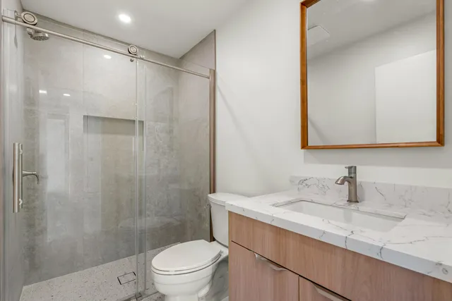 a bathroom with a sink a toilet and shower