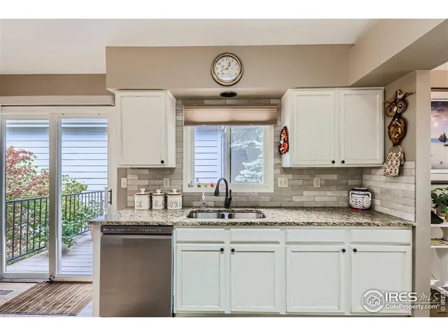 a kitchen with kitchen island granite countertop a sink a stove a refrigerator a dining table and chairs