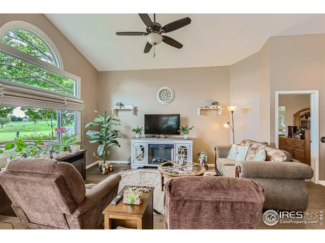 a living room with furniture fireplace and a large window