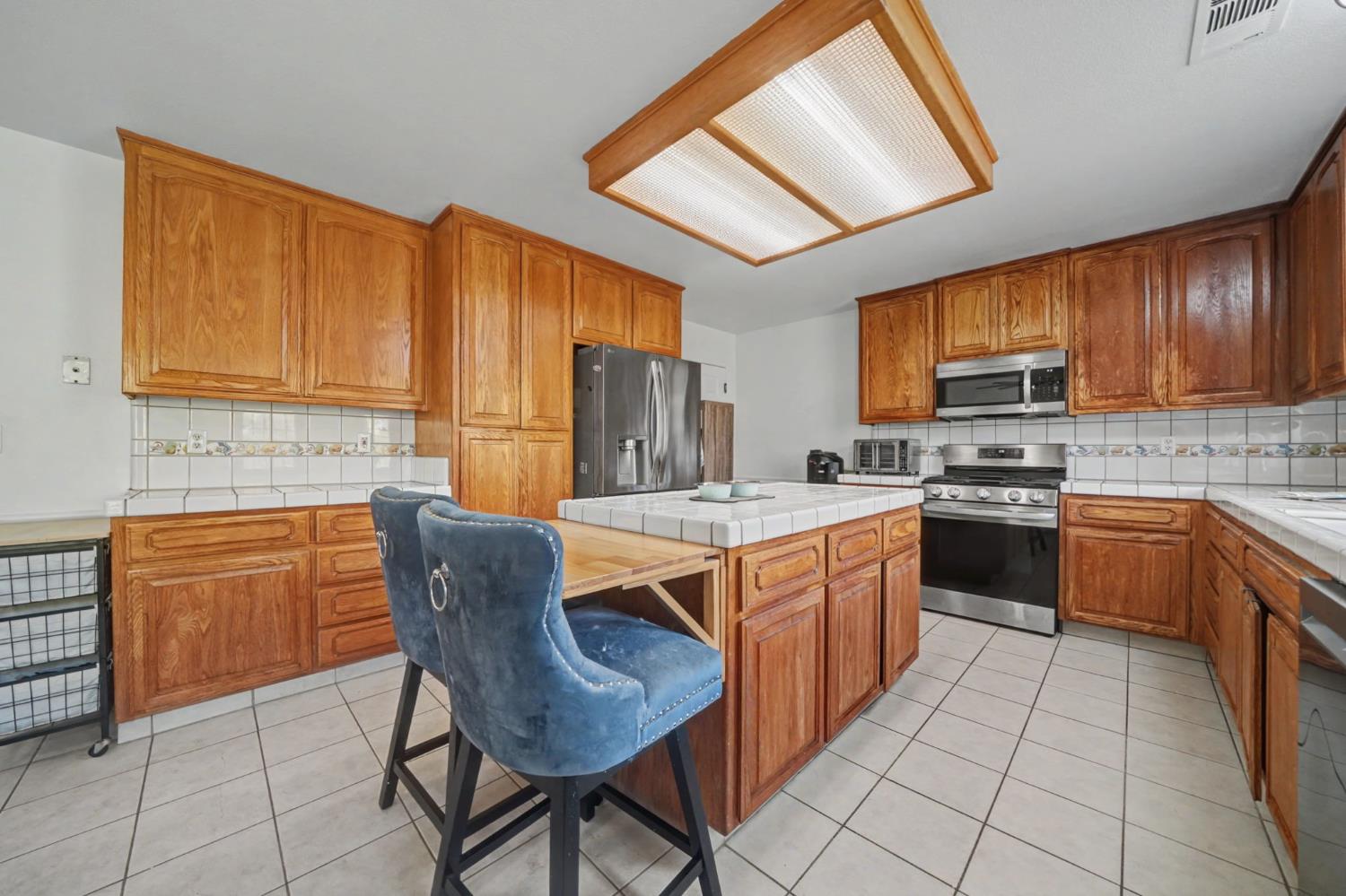 7761 Jenny Lind Road Valley Springs, CA 95252 - Photo 12 of 35 a kitchen with stainless steel appliances granite countertop a stove a sink dishwasher and a refrigerator