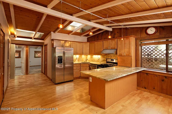a kitchen with stainless steel appliances granite countertop a sink window and cabinets