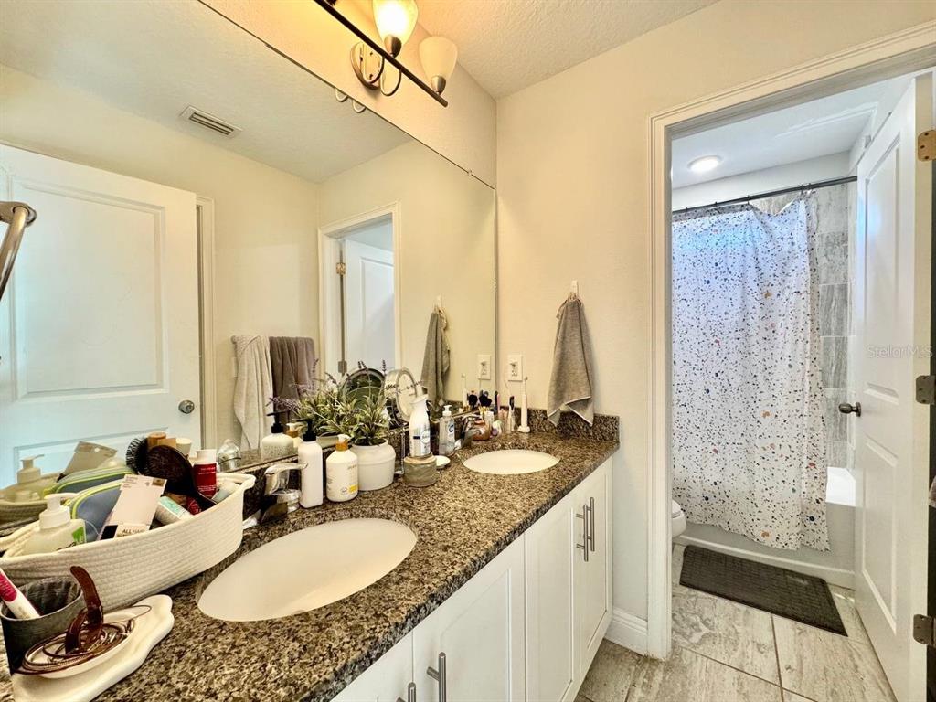 2951 West Cherry Street Tampa, FL 33607 - Photo 20 of 25 a bathroom with double vanity sinks a mirror and a shower