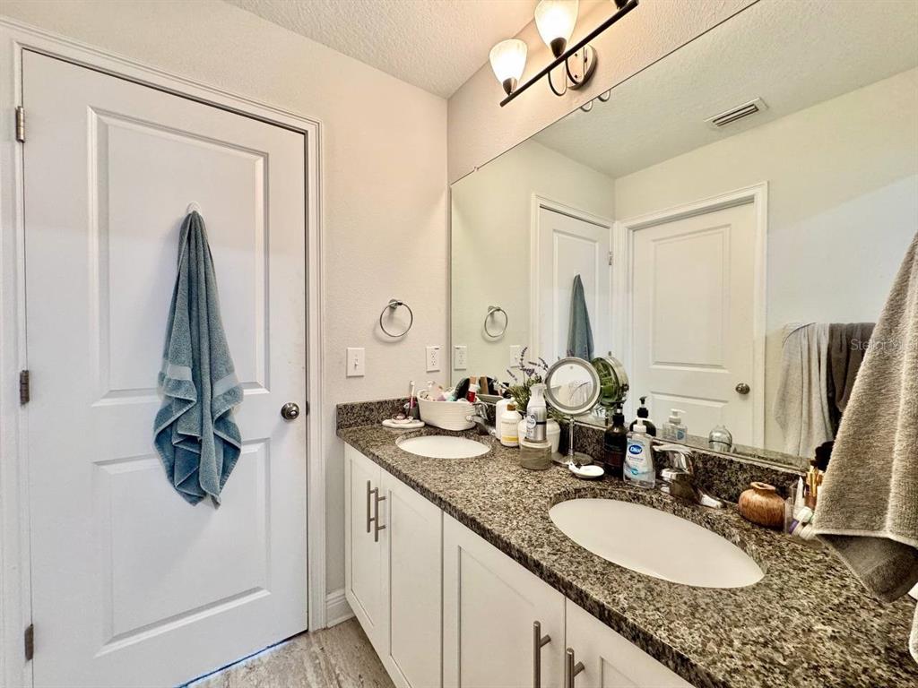 2951 West Cherry Street Tampa, FL 33607 - Photo 21 of 25 a bathroom with a granite countertop sink and a mirror