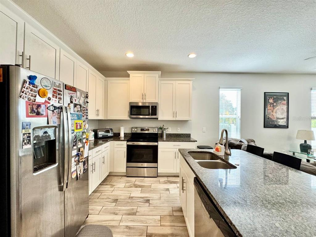 2951 West Cherry Street Tampa, FL 33607 - Photo 9 of 25 a kitchen with stainless steel appliances granite countertop a sink dishwasher stove and refrigerator