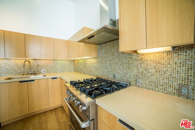 a kitchen with a sink a stove and cabinets