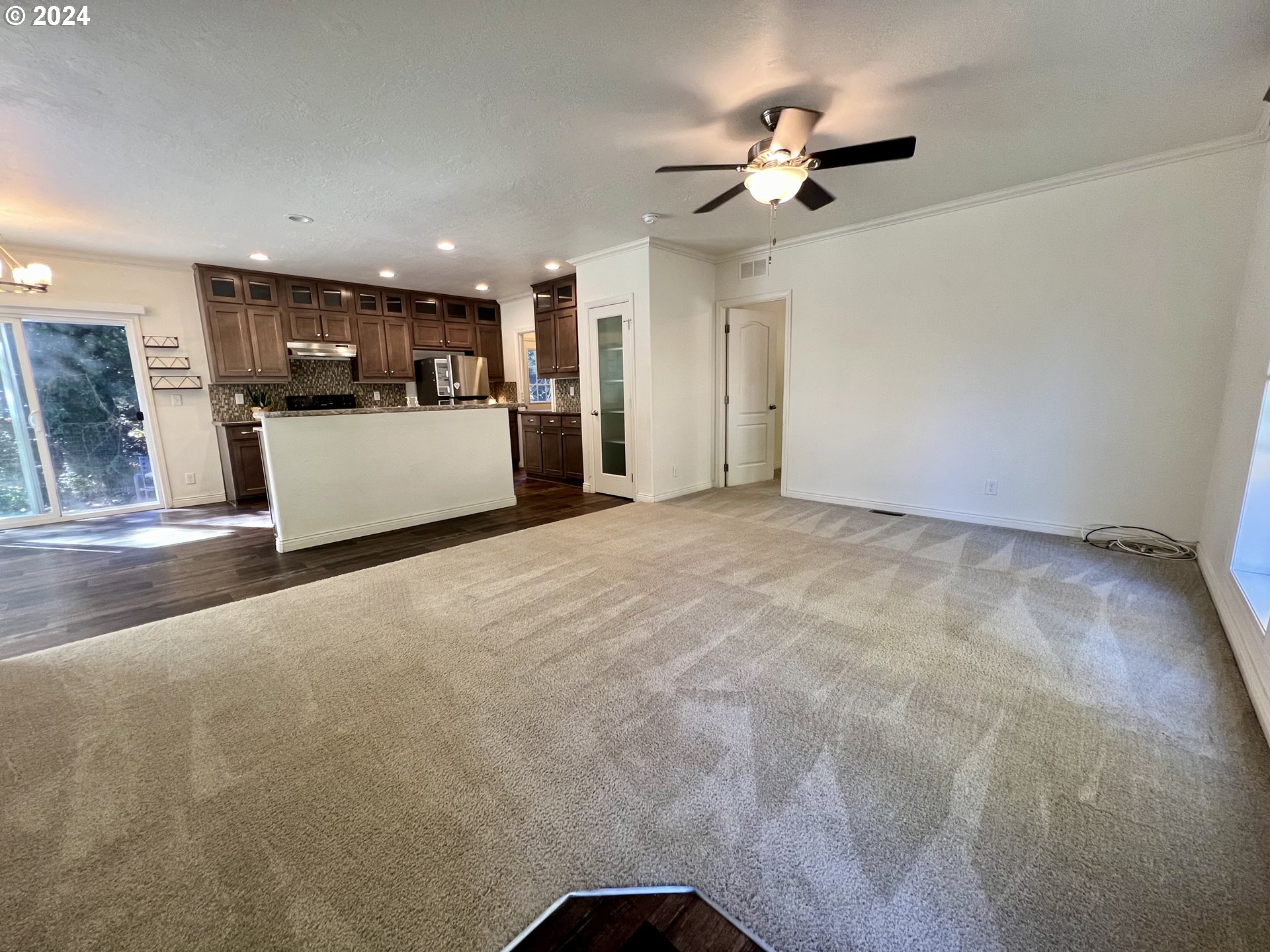 28312 Mateer Road Gold Beach, OR 97444 - Photo 3 of 25 a view of a livingroom with a ceiling fan kitchen view and a chandelier