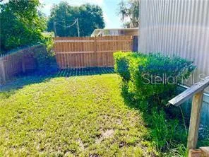 a view of a backyard with plants and wooden fence