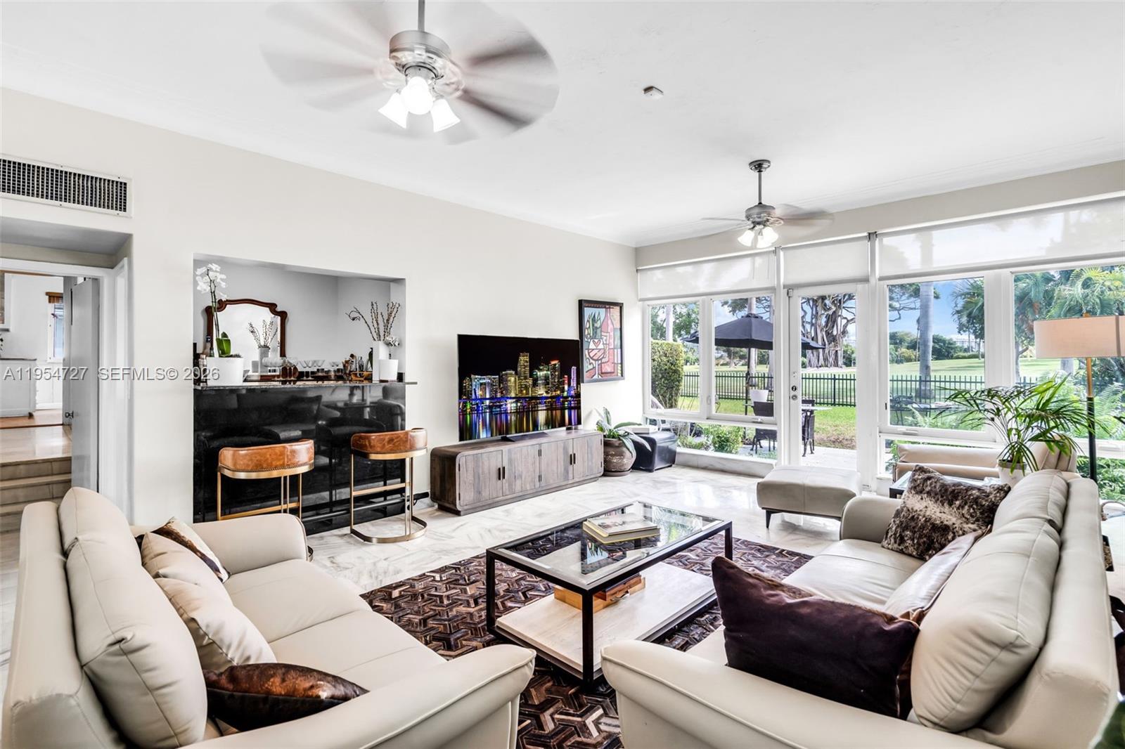 5965 Alton Road Miami Beach, FL 33140 - Photo 15 of 29 a living room with furniture and a flat screen tv
