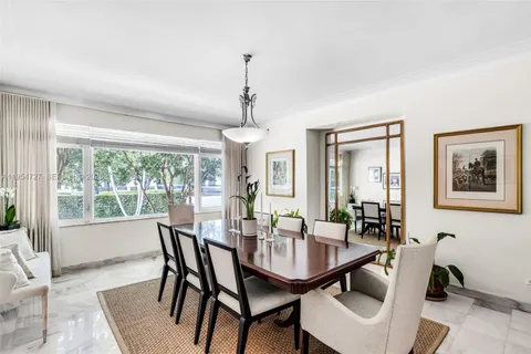a dining room with furniture a chandelier and wooden floor