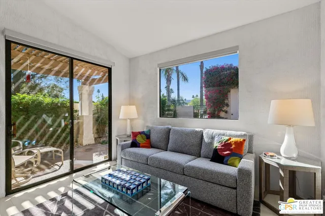 a living room with a couch and a floor to ceiling window